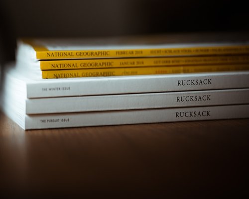 Close up of academic reference books and encyclopedias stacked on a desk