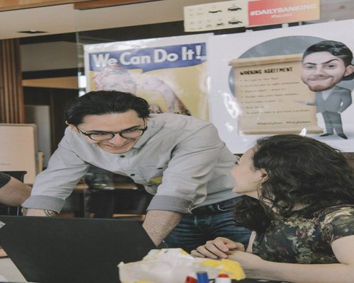 Young student receiving help from a librarian at a computer desk
